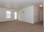 Thumbnail 21 of 24 - A room with a carpeted floor and a door on the right side.