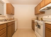 Thumbnail 17 of 24 - A kitchen with wooden cabinets and white appliances.
