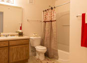 Thumbnail 22 of 24 - A bathroom with a toilet, sink, and shower.