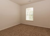 Thumbnail 8 of 24 - A room with a carpeted floor and a window.