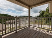 Thumbnail 15 of 24 - A wooden deck with a white railing overlooks a residential street.
