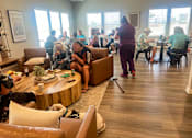 Thumbnail 58 of 58 - people sitting in a living room with couches and tables