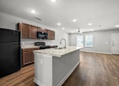 Thumbnail 2 of 58 - a kitchen with a large island and a black refrigerator