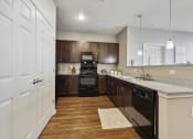 Thumbnail 12 of 22 - kitchen with a large island and black appliances at The Lofts apartments in Slidell, LA