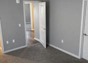 Thumbnail 4 of 7 - A room with a ceiling fan and carpeted floor.