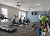 Thumbnail 3 of 7 - A gym with a variety of equipment including treadmills, exercise bikes, and weightlifting equipment.