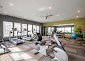Thumbnail 7 of 31 - Fitness center with treadmills and other exercise equipment at Mosaic Apartments in Avon, Indiana
