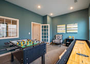 Thumbnail 6 of 31 - Game room with a foosball table and shuffle board at Mosaic Apartments in Avon, Indiana