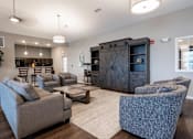 Thumbnail 3 of 31 - Clubhouse living room with couches chairs and a coffee table at Mosaic Apartments in Avon, Indiana