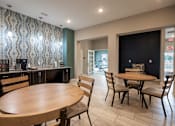 Thumbnail 5 of 31 - Clubhouse room with a table and chairs and a counter with a coffee maker at Mosaic Apartments in Avon, Indiana