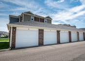 Thumbnail 14 of 31 - A row of garages with white doors at Mosaic Apartments in Avon, Indiana