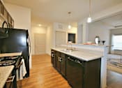 Thumbnail 17 of 31 - a kitchen with an island and a black refrigerator