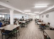 Thumbnail 11 of 16 - A large room with tables and chairs.