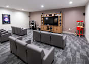 Thumbnail 7 of 16 - A living room with grey couches and a television.