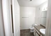 Thumbnail 12 of 13 - A white bathroom with a toilet, sink, and mirror.