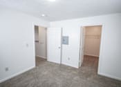 Thumbnail 11 of 13 - A room with a carpeted floor and three doors.