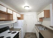 Thumbnail 6 of 13 - A kitchen with a white door and a stove top oven.