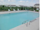 Thumbnail 5 of 13 - A pool with a ladder and chairs around it.