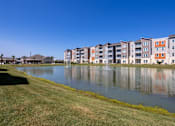 Thumbnail 11 of 31 - Pond in front of Promenade apartments with a clear blue sky
