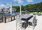 Thumbnail 23 of 44 - A patio with a table and chairs overlooking a pool.