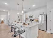 Thumbnail 55 of 57 - a large kitchen with an island with bar stools and a stainless steel refrigerator