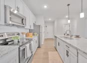 Thumbnail 48 of 57 - a large kitchen with marble counter tops and white cabinets