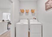 Thumbnail 50 of 57 - two washers and dryers in a laundry room with a door to a kitchen