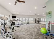 Thumbnail 20 of 25 - A gym with a variety of equipment including treadmills, weights, and exercise machines.
