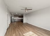 Thumbnail 3 of 25 - A room with a ceiling fan and wooden flooring.