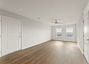Thumbnail 4 of 25 - A room with wooden floors and white walls.
