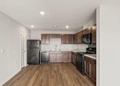 Thumbnail 2 of 25 - A kitchen with wooden cabinets and black appliances.