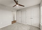 Thumbnail 6 of 25 - A room with a ceiling fan and two doors.