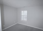Thumbnail 12 of 18 - A room with a window and carpeted floor.