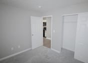 Thumbnail 10 of 18 - A room with a carpeted floor and white walls.