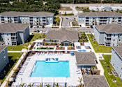 Thumbnail 48 of 83 - An aerial view of a swimming pool surrounded by apartment buildings.