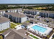 Thumbnail 49 of 83 - A large apartment complex with a swimming pool in the middle.