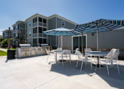 Thumbnail 54 of 83 - A patio with a table and chairs and an umbrella.