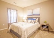Thumbnail 18 of 22 - Apartment bedroom with a bed, nightstand and two pictures at Trillium apartments in Melbourne fl