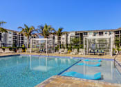 Thumbnail 7 of 96 - A large swimming pool with a blue tiled edge and a metal fence around it.