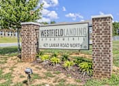 Thumbnail 33 of 33 - A sign for Westfield Landing Apartments stands in front of a brick building.