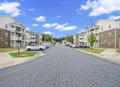 Thumbnail 15 of 33 - A street view of a residential area with apartment buildings on both sides.