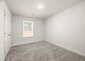 Thumbnail 7 of 33 - A room with a carpeted floor and a window.