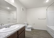 Thumbnail 11 of 33 - A bathroom with a sink, toilet, and bathtub.