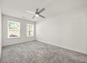 Thumbnail 9 of 33 - A room with a ceiling fan and car pictures on the wall.