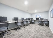 Thumbnail 21 of 33 - A conference room with a carpeted floor and grey chairs.