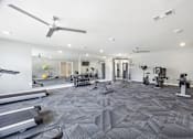 Thumbnail 20 of 33 - A spacious gym with treadmills, elliptical machines, and other exercise equipment.