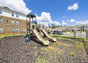 Thumbnail 17 of 33 - A playground with a slide and a blue slide.