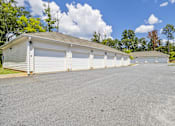 Thumbnail 25 of 33 - A row of garages with trees in the background.
