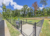 Thumbnail 16 of 33 - A fenced area with a sign and a tree in the background.