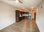 Thumbnail 11 of 15 - A spacious kitchen with dark wood cabinets and a ceiling fan.